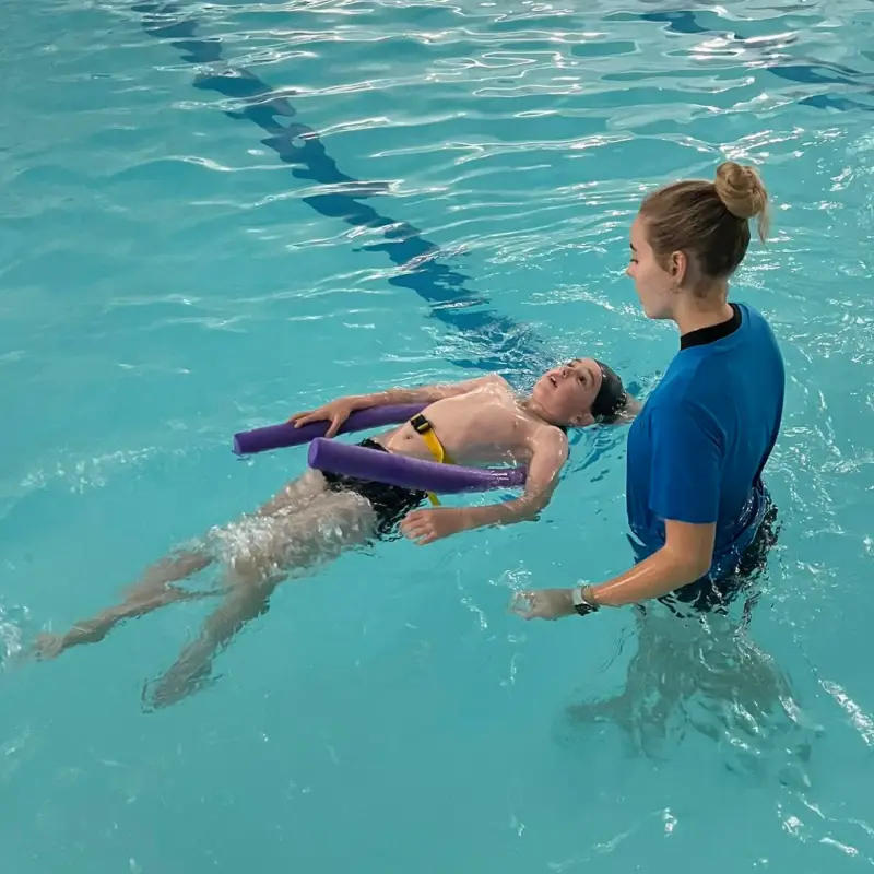 A boy practicing floating during a lesson with Helen Diamond Swimming